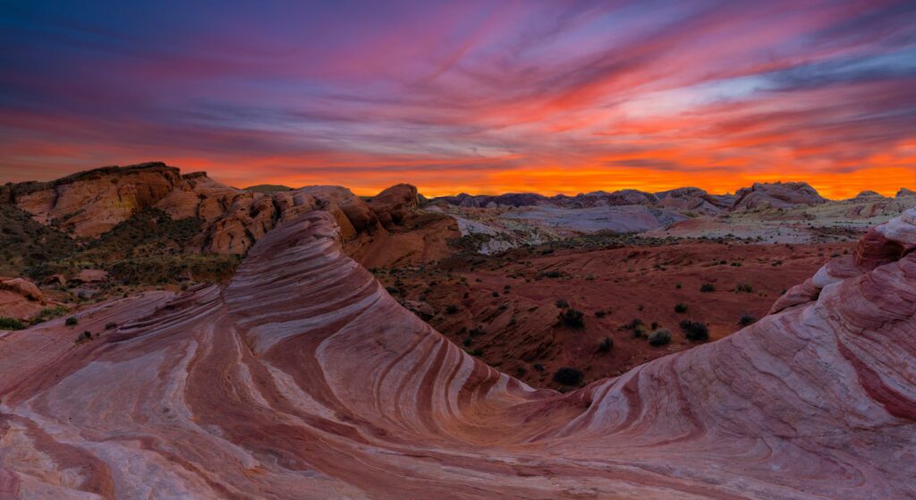 The sun sets in the background with Red Rock Canyon in full view, a site for hiking, camping, and more in Nevada.
